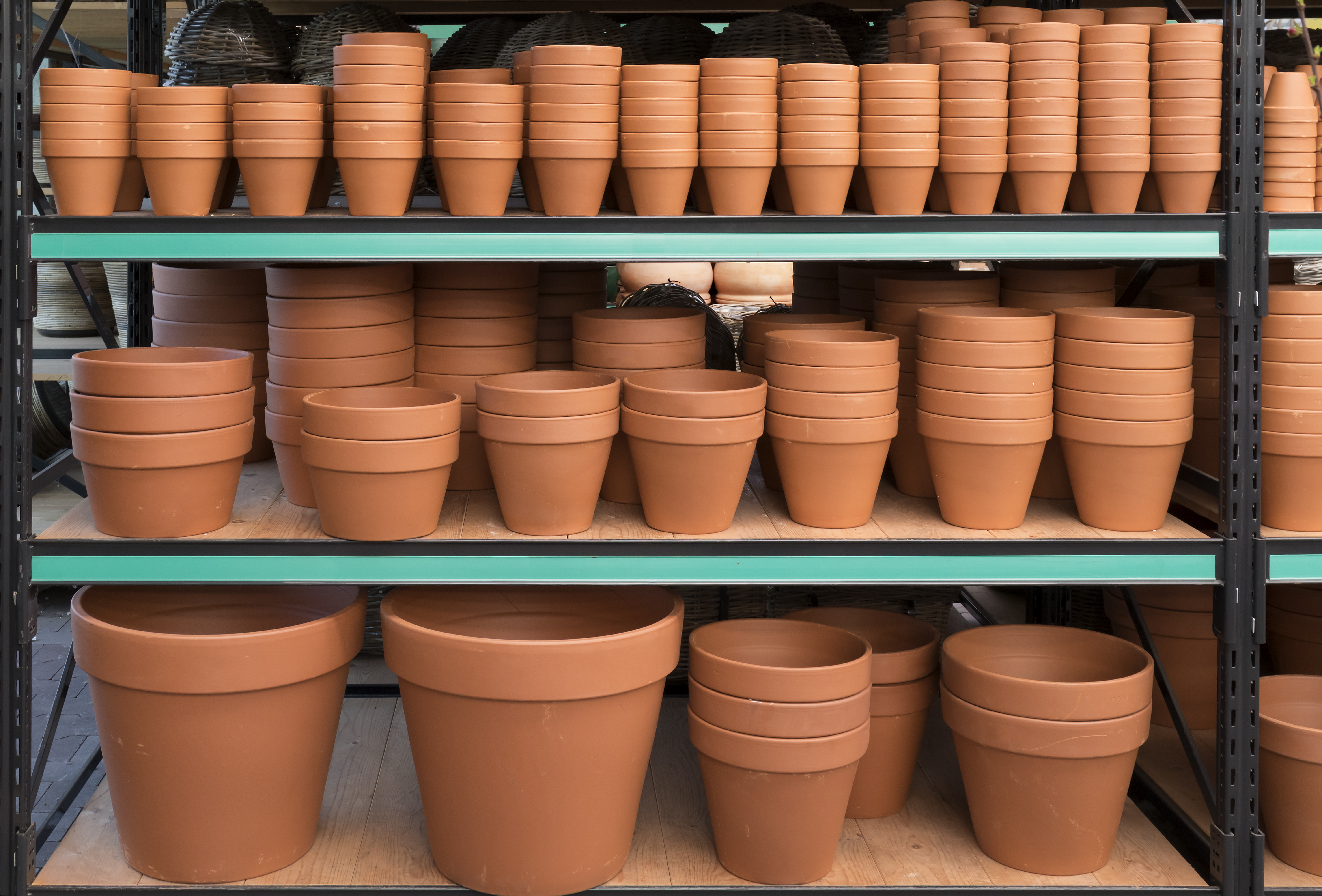 Shelves of different sized tan pots.